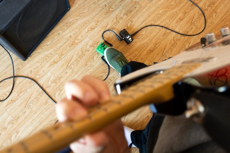 Gitarrenspieler bedient Effektgerät - Problemsuche wenn der Verstärker brummt