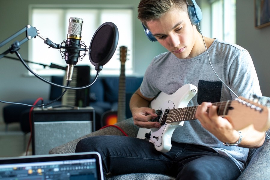 Junger Mann spielt zuhause E-Gitarre