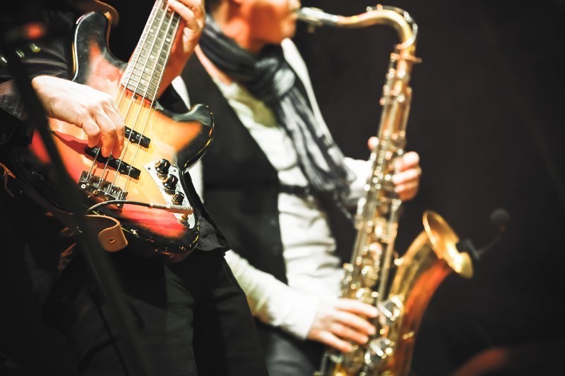 A saxophonist and a bassist are making music together on stage with a bass amp